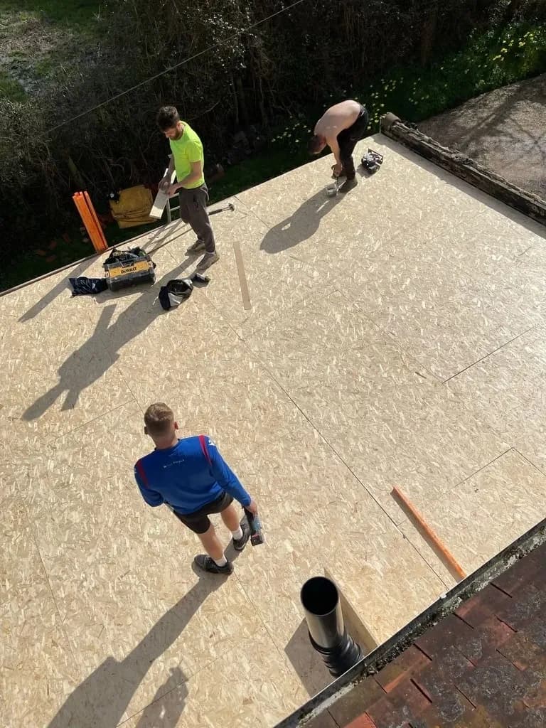 Team installing OSB decking on flat roof